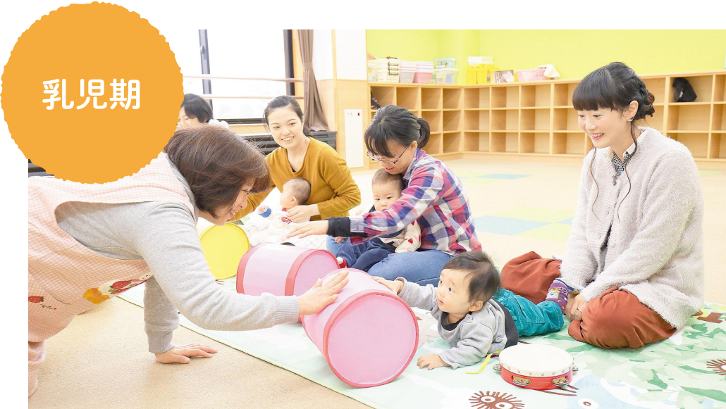 保育士と遊ぶ赤ちゃん、見守るお母さんの様子